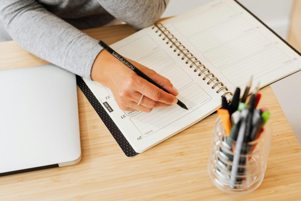 Calendar and planner on desk with flowers and tea, illustrating timing importance for hormone testing.