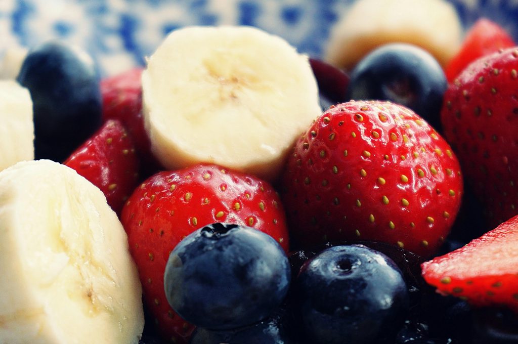 Close-up of fresh strawberries, blueberries, and sliced banana, key ingredients used in hormone balancing smoothies for women to support energy and hormone health.