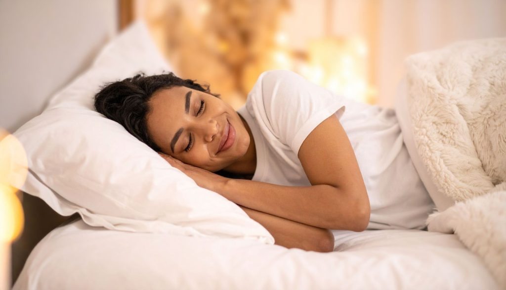 Woman resting peacefully in bed, representing a 10-minute evening ritual for better sleep and hormone support after 40