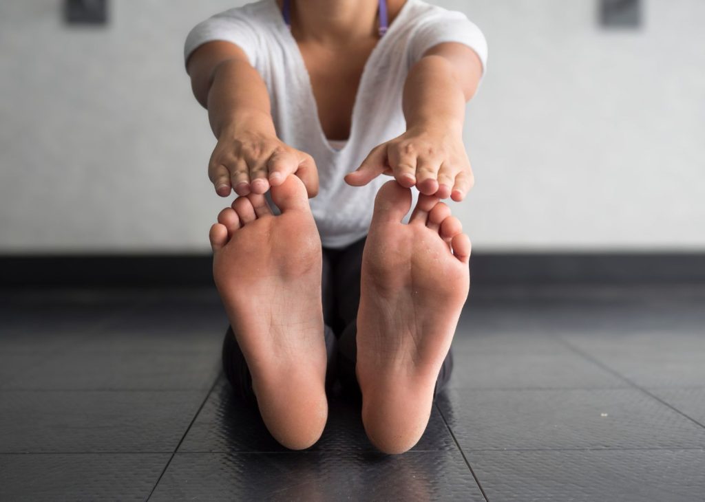 Woman stretching on a mat, representing gentle movement and flexibility exercises that help reduce cortisol and support stress balance after 40.