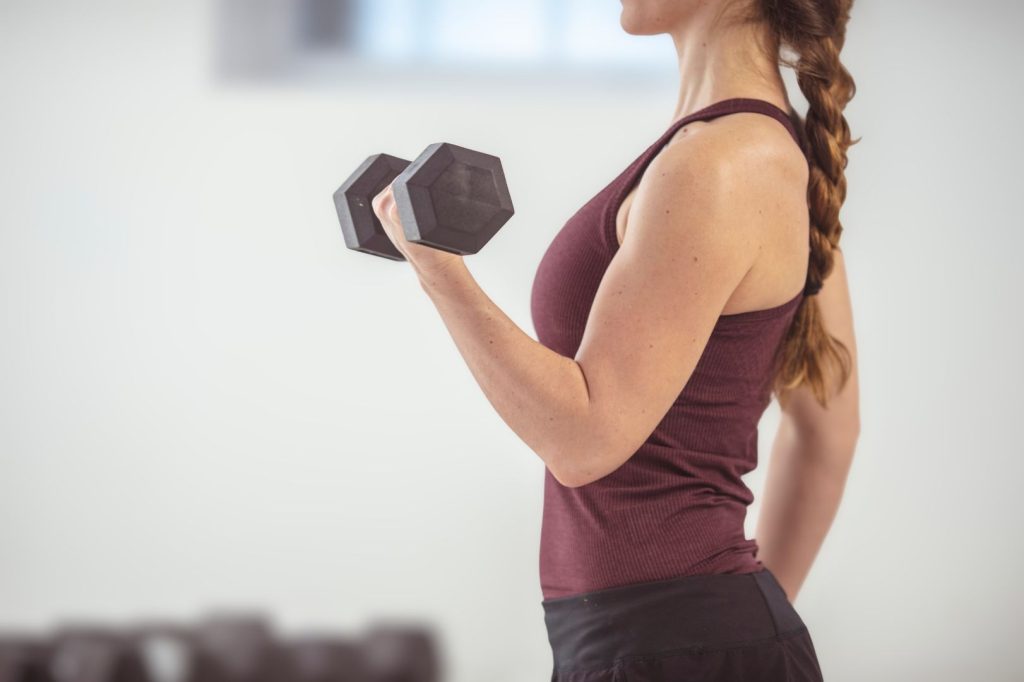 Woman lifting a dumbbell during strength training, representing hormone-friendly workouts that support muscle and metabolism after 40.