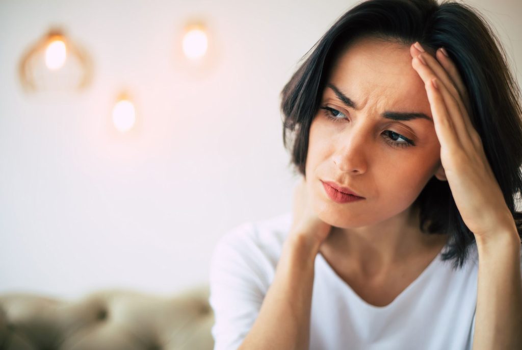 Woman experiencing stress and emotional strain related to postpartum hormone imbalance